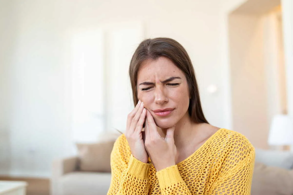 douleur-dentaire-soudaine-femme femme souffrant d'une douleur dentaire soudaine à domicile