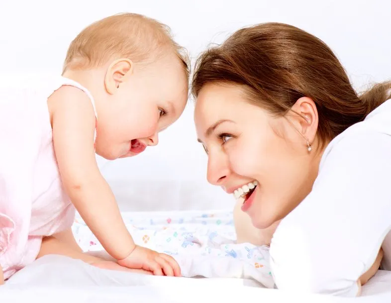 une maman qui joue avec son bébé sur un matelas adapté