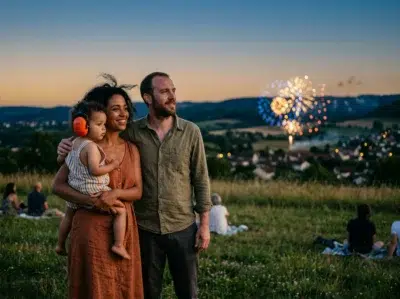 Famille regardant un feu d'artifice à distance le soir, tout-petit portant un casque anti-bruit