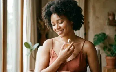 parfum-personnalite-cover-douce femme au sourire discret tenant un flacon de parfum, lumière naturelle douce