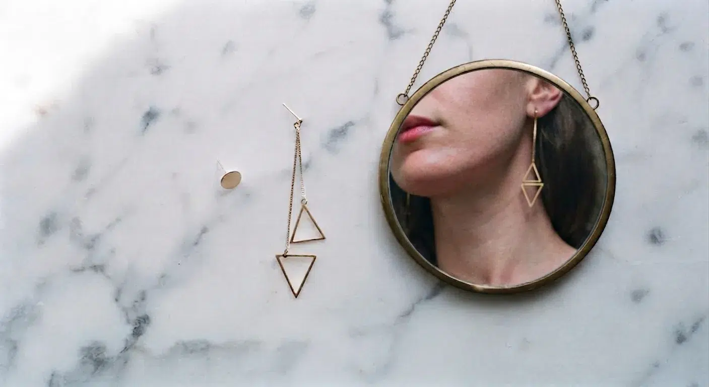 Comparaison de deux boucles d'oreilles selon la forme du visage devant un miroir